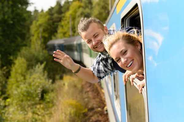 Couple waving with heads out train window