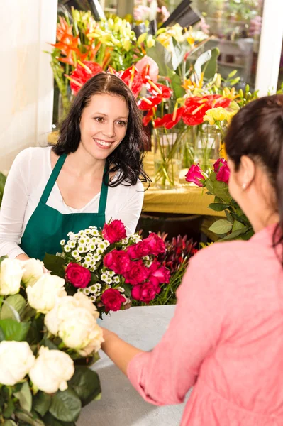 Happy florist making roses bouquet women customer