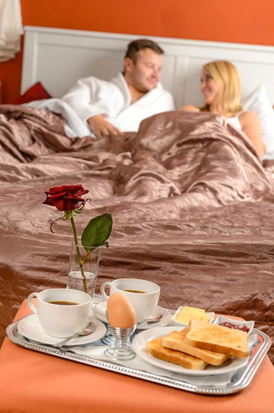 Happy couple lying bed romantic breakfast hotel