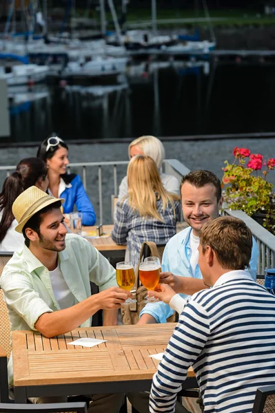 Three men drinking beer at terrace bar