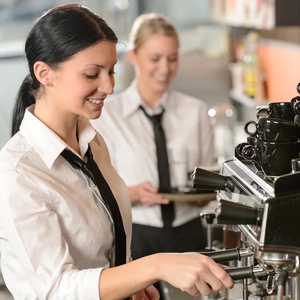 female barista operating coffee maker machine
