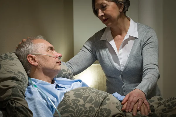 Worried senior woman caring with sick husband