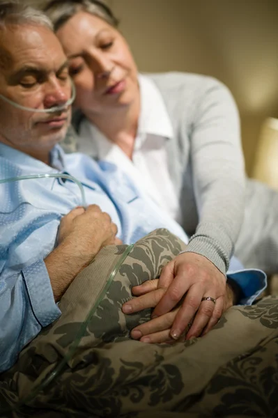 Loving elderly couple sleeping in bed