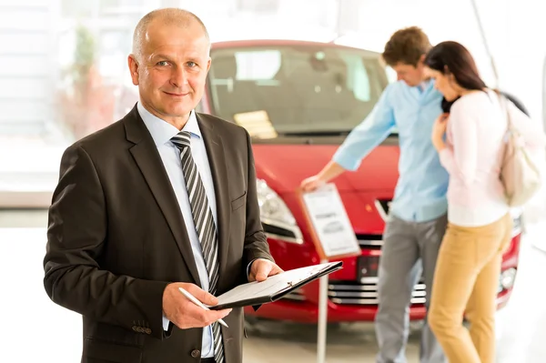 Portrait of salesman in car retail store