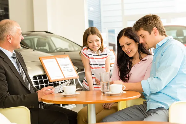 Couple reading papers in car dealership