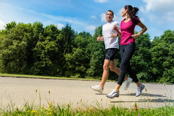 Portrait of fit couple running outdoors