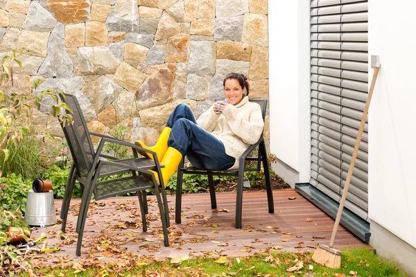 Happy woman relaxing autumn patio drinking tea