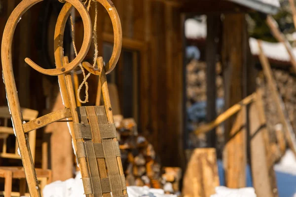 Wooden sledge outside winter cottage snow