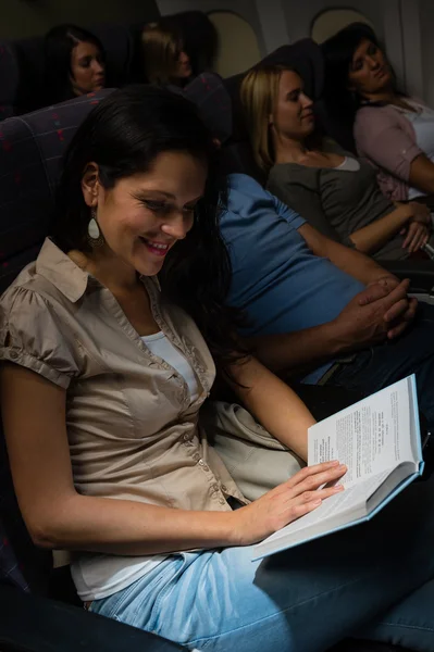 Young woman read book plane night flight