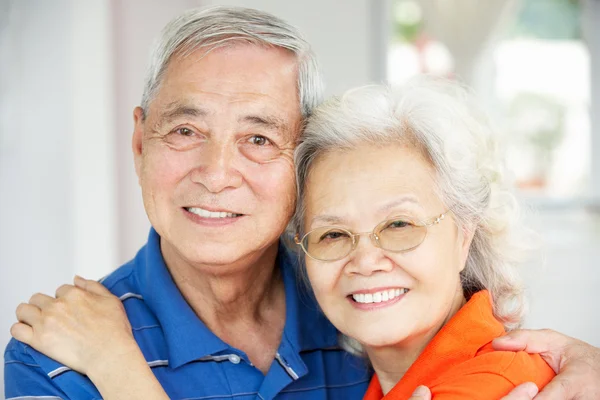Senior Chinese Couple Relaxing On Sofa At Home