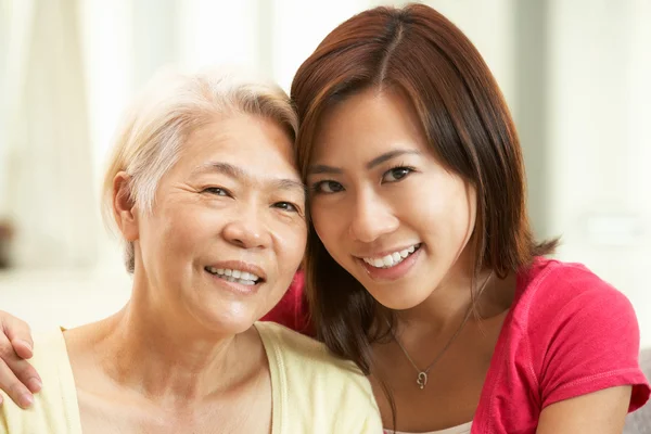 Portrait Of Chinese Mother With Adult Daughter Relaxing At Home