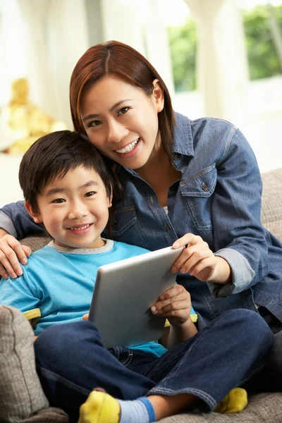 Chinese Mother And Son Using Tablet Computer Whilst Sitting On S