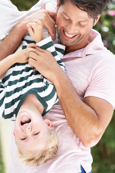 Father Holding Son Upside Down Outdoors