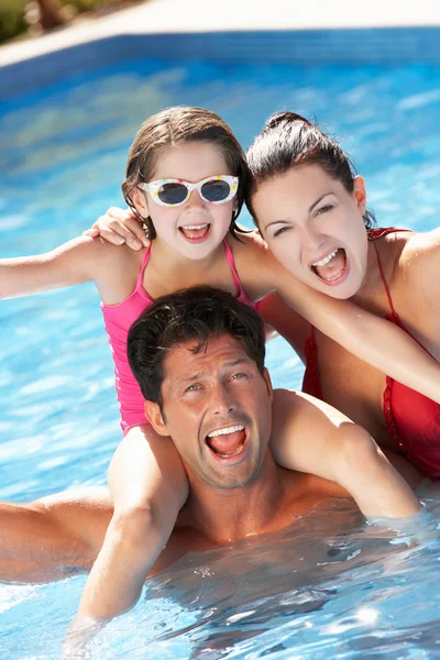 Family Having Fun In Swimming Pool