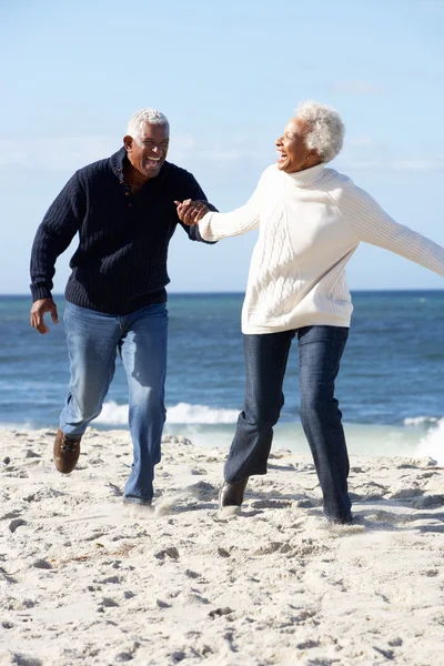Romantic Senior Couple Running Along Beach