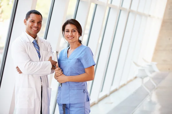 Medical Staff Having Discussion In Modern Hospital Corridor