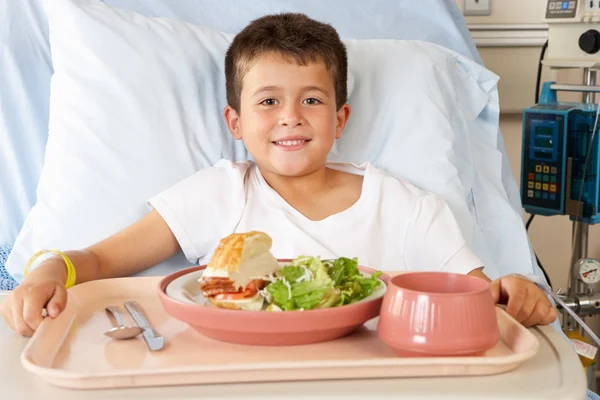 Boy Eating Meal In Hospital Bed