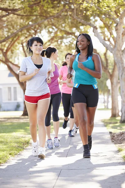 Group Of Female Runners Exercising On Suburban Street