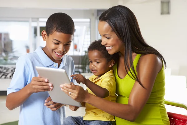Mother And Children Using Digital Tablet In Kitchen Together