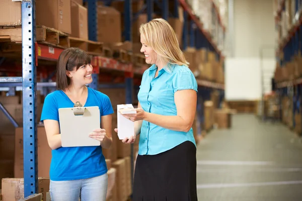 Businesswoman And Female Worker In Distribution Warehouse