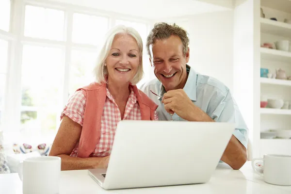 Middle Aged Couple Looking At Laptop