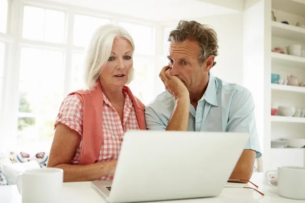 Middle Aged Couple Looking At Laptop