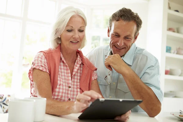 Middle Aged Couple Looking At Digital Tablet