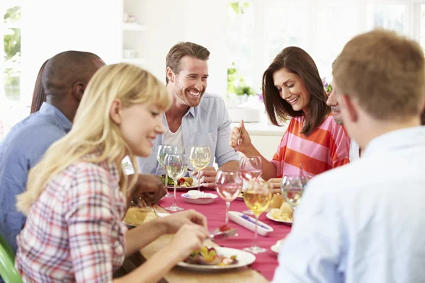 Friends Sitting Around Table Having Dinner