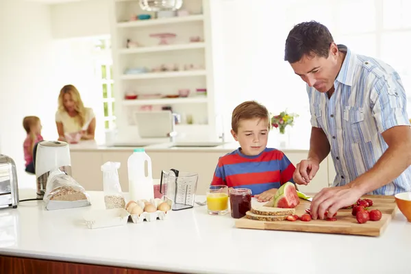 Son Helping Father To Prepare Family Breakfast