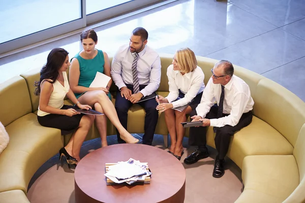 Group Of Businesspeople Having Meeting In Office Lobby