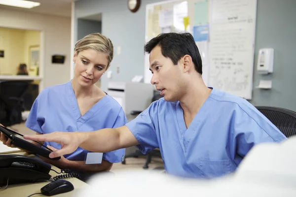 Male And Female Nurse Working At Nurses Station