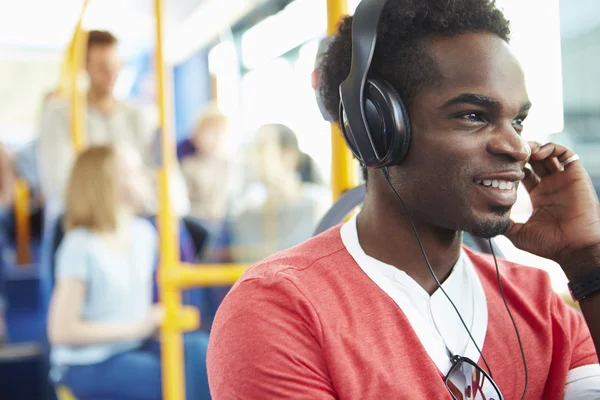 Man Wearing Headphones Listening To Music On Bus Journey