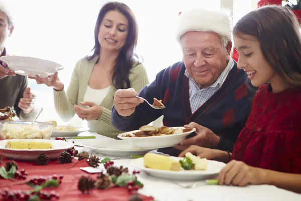 Multi Generation Family Enjoying Christmas Meal At Home