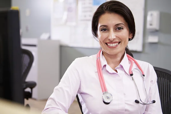 Portrait Of Doctor Working At Nurses Station