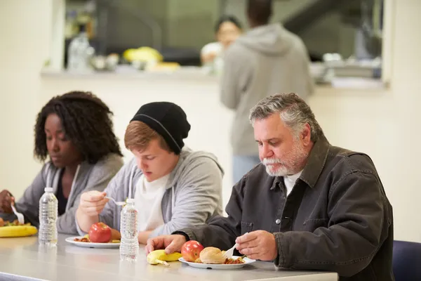 People  Eating In Homeless Shelter