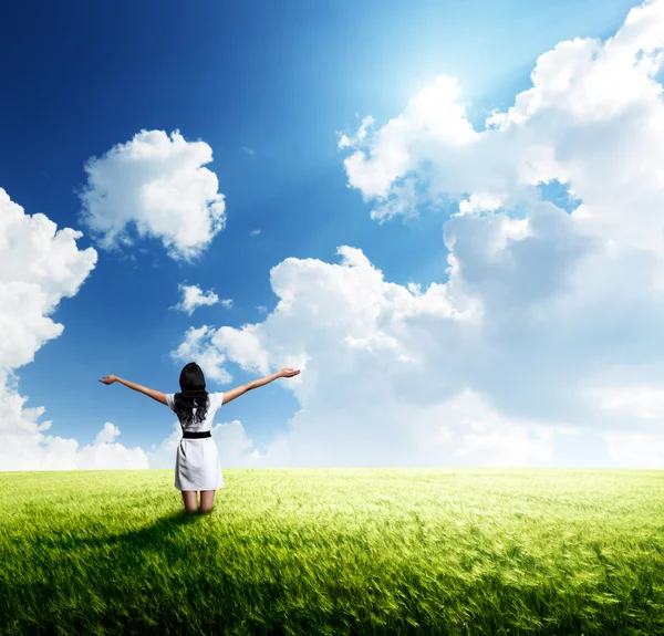 Happy young woman in white dress standing in field