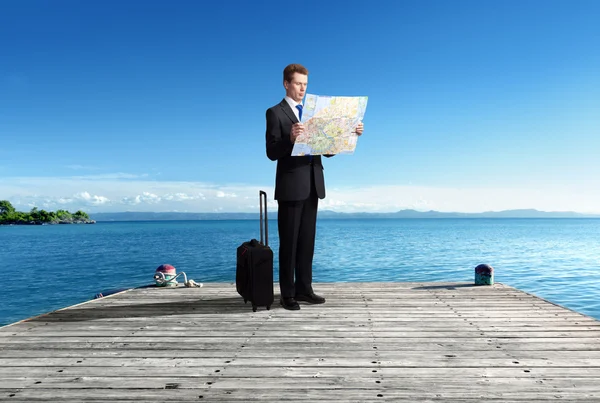 Business man standing on pier whith map in hands