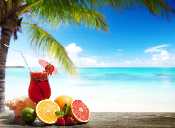 Strawberry cocktail and tropical fruit on the beach