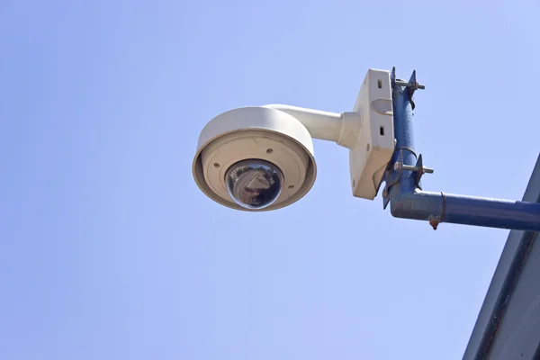 Hi-tech dome type surveillance camera over blue sky