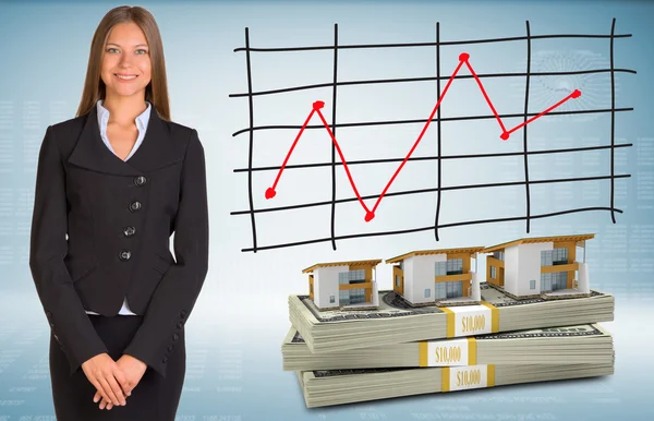 Businesswoman with houses and money