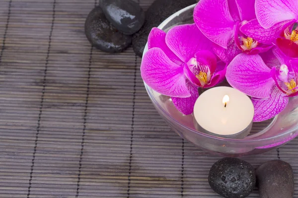 Orchids with candle and massage stones