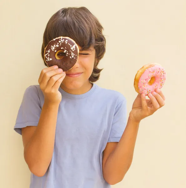 Boy playing with donuts