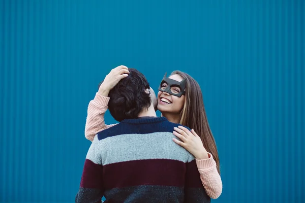 Girl in a mask kissing her young guy.