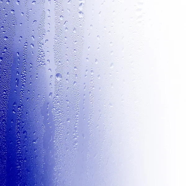 Water on glass, background of blue water