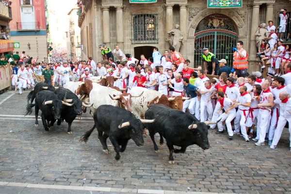 PAMPLONA, SPAIN-JULY 9: People run from bulls on street during S