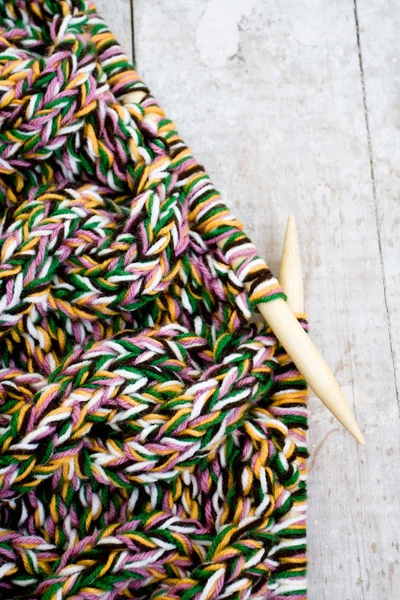 Knitting needles and yarn on wooden background