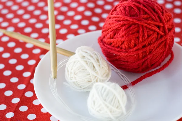 Bright balls of yarn and knitting needles on a background