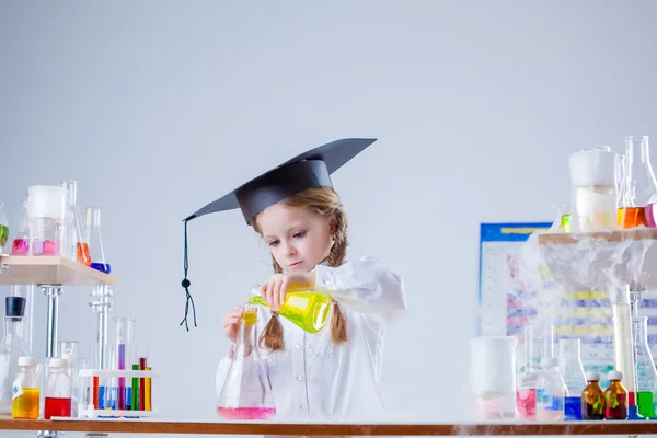 Studio shot of pretty young schoolgirl mixes tubes