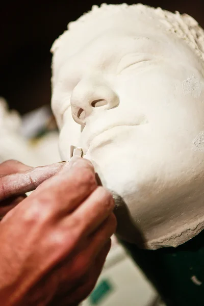 Artist sculpting a face