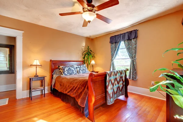 Bedroom with Brown walls with cherry hardwood floor.